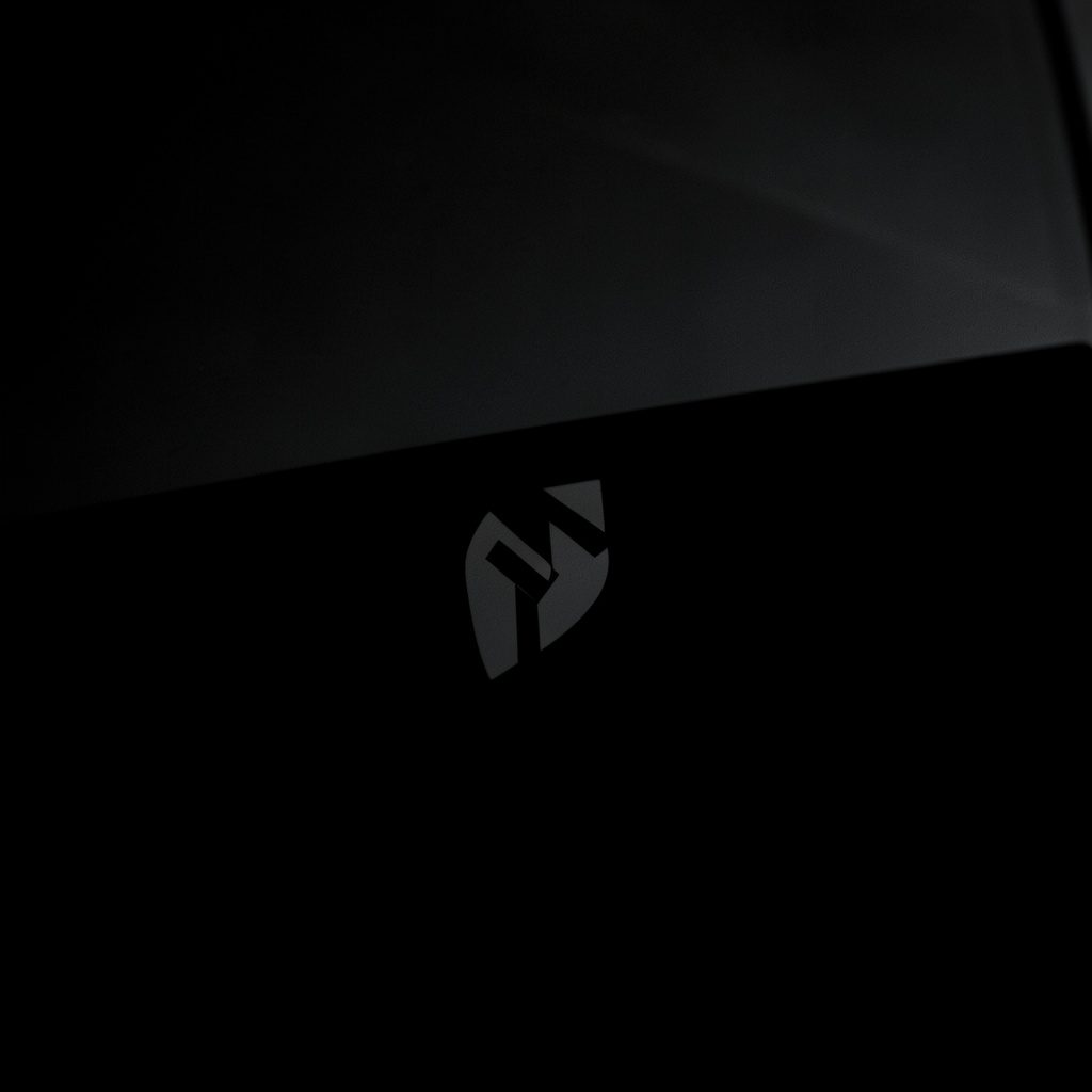 A moody, shadow-rich image of a conference logo, with muted charcoal and warm blush tones.